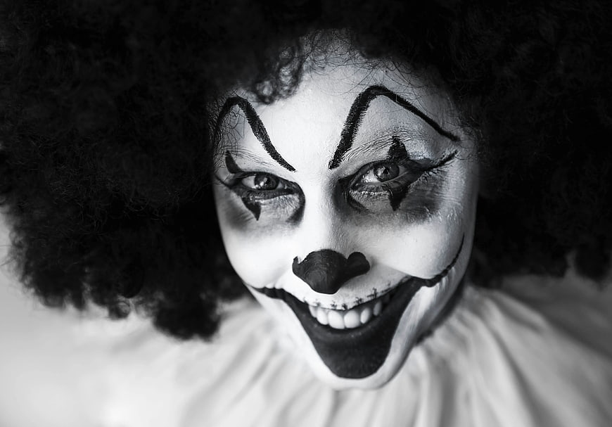 Scary clown face with stitches and dark makeup