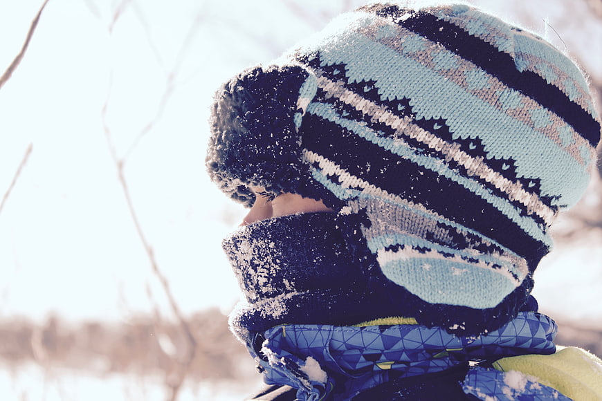 Child in Winter Hat and Scarf in Snowy Landscape