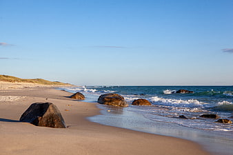 Sandy Beach with Large Boulders and Ocean Waves