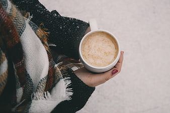Woman holding hot coffee cup in snowy winter