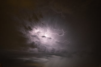 Dramatic Lightning Strike Illuminating Dark Storm Clouds at Night