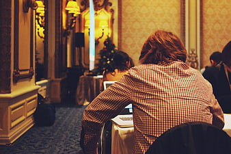 Man working on laptop at conference in ornate room