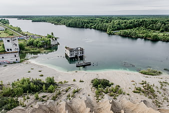 Aerial view of abandoned buildings submerged in a flooded quarry lake
