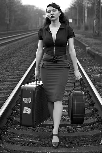 Vintage Pin-up Woman Walking on Train Tracks with Suitcases