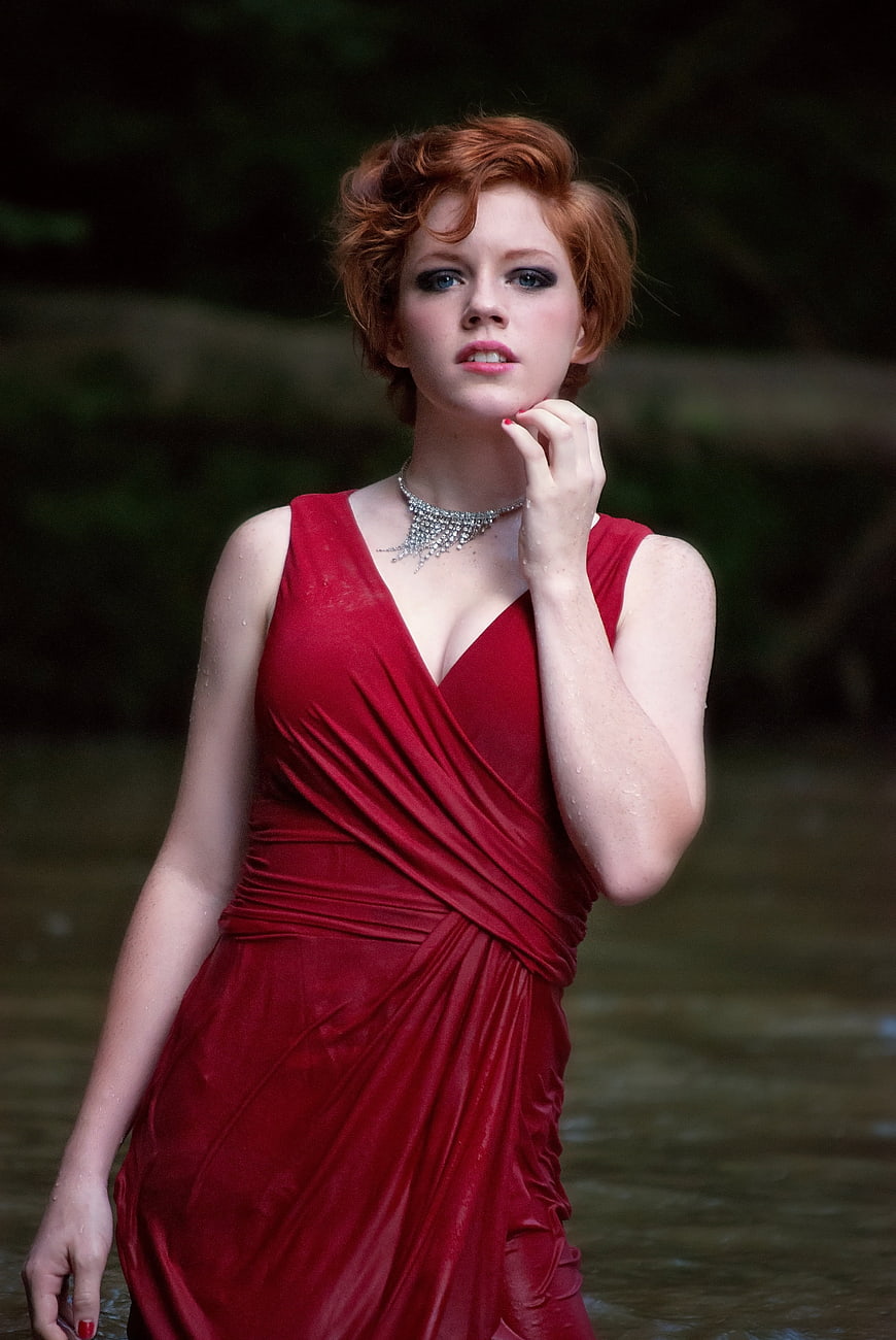 Redhead Woman in Red Dress Standing in Water