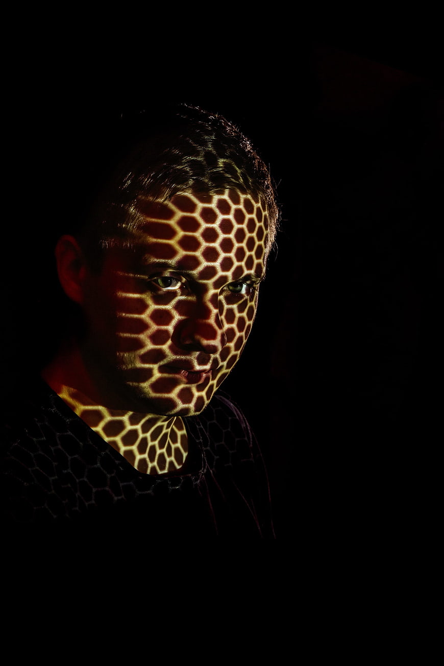 Portrait of man with honeycomb light pattern on face