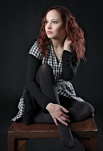 Thoughtful Redhead Woman Sitting on Wooden Bench