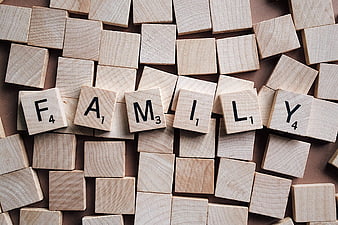 Wooden Scrabble Tiles Spelling Family on Brown Background