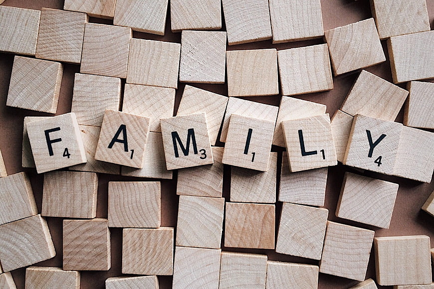 Wooden Scrabble Tiles Spelling Family on Brown Background