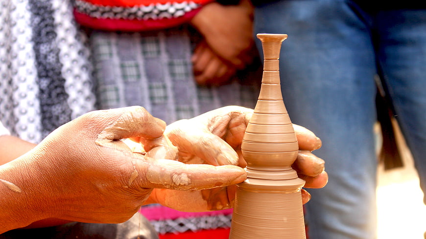 Close-up of hands shaping clay pottery on a wheel