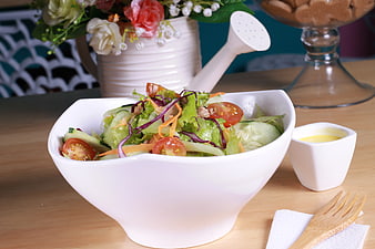 Fresh vegetable salad in white bowl with dressing