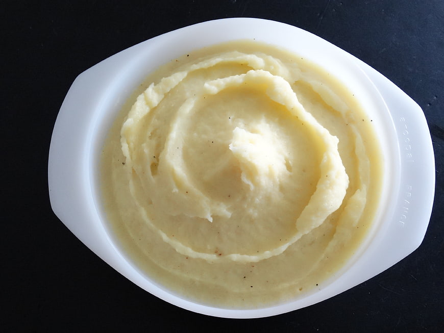 Creamy Mashed Potatoes In White Ceramic Bowl On Black Background