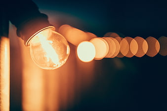 Close-up of glowing vintage light bulb with bokeh background