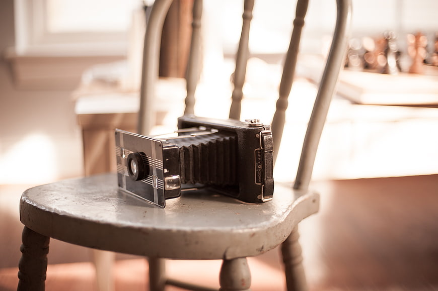 Vintage folding camera on rustic wooden chair