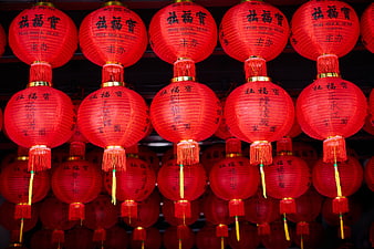 Rows of red Chinese lanterns with calligraphy hanging at night