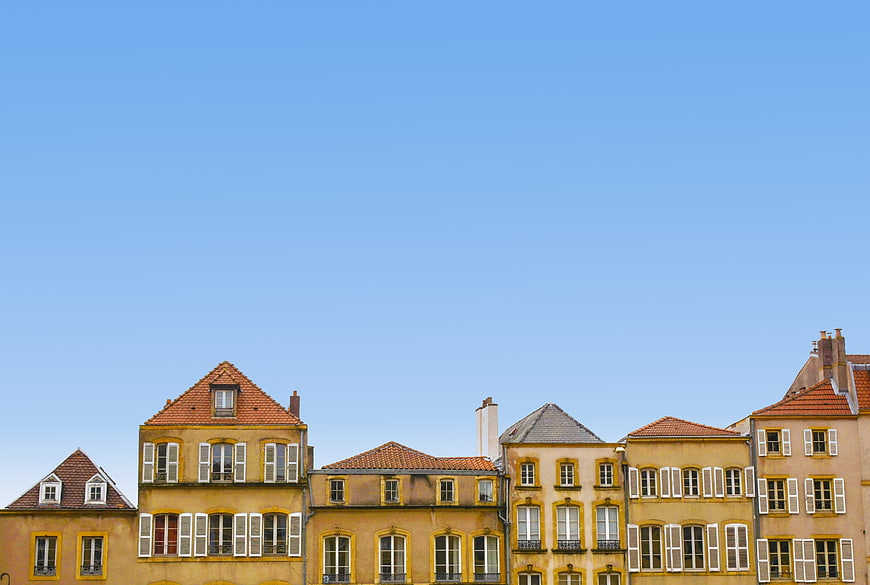 Historic European Townhouses With Red Roofs Against Clear Blue Sky