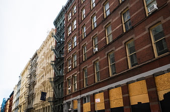 Low angle view of urban brick buildings with boarded windows