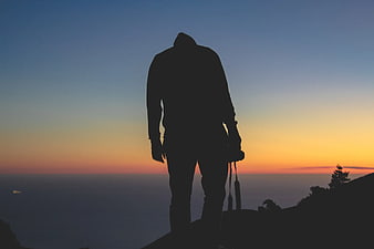 Silhouette of Photographer on Mountain Peak at Sunset