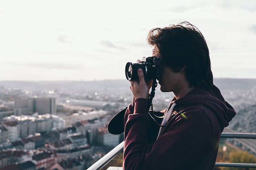 Young Man Photographing Cityscape with DSLR Camera