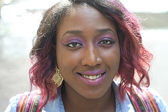 Portrait of smiling woman with purple makeup and red hair