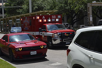 Red Dodge Charger and Houston Fire Ambulance on City Street