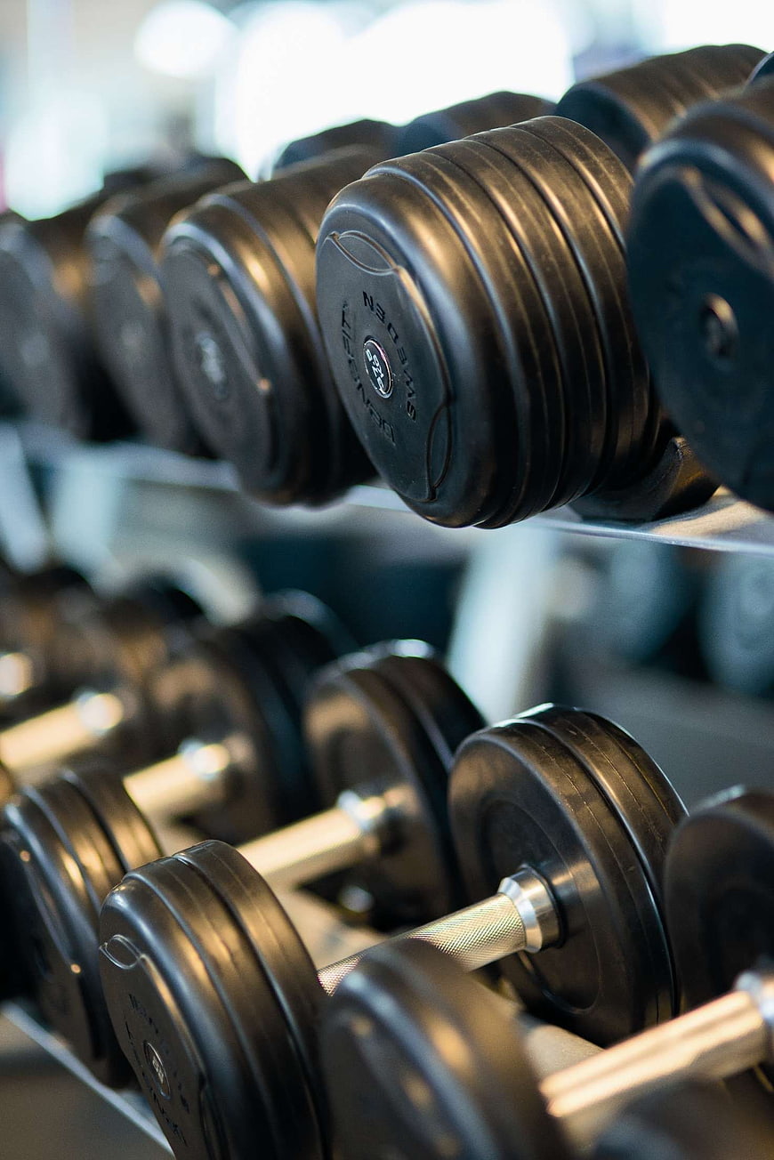 Close-up of black dumbbells on a gym rack
