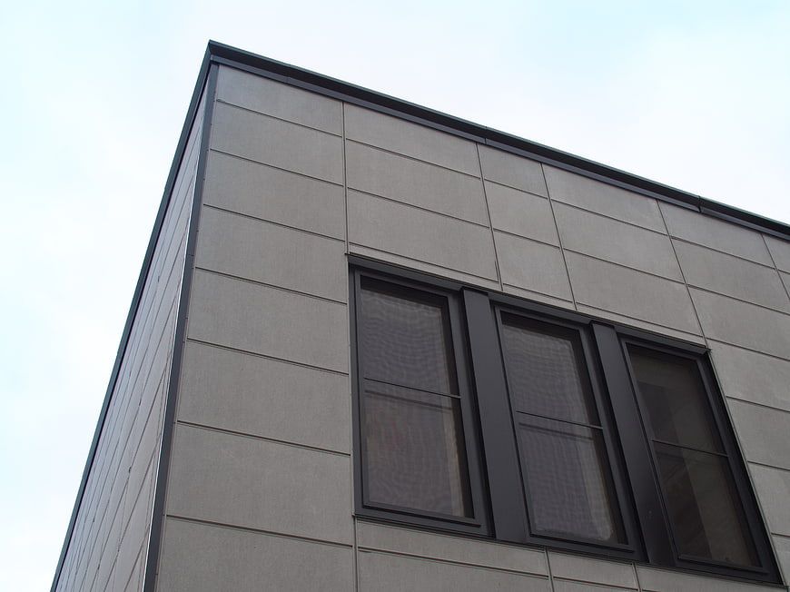 Modern gray building facade with black windows