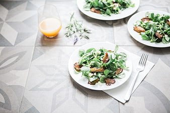 Healthy green salad with mushrooms and orange juice on table