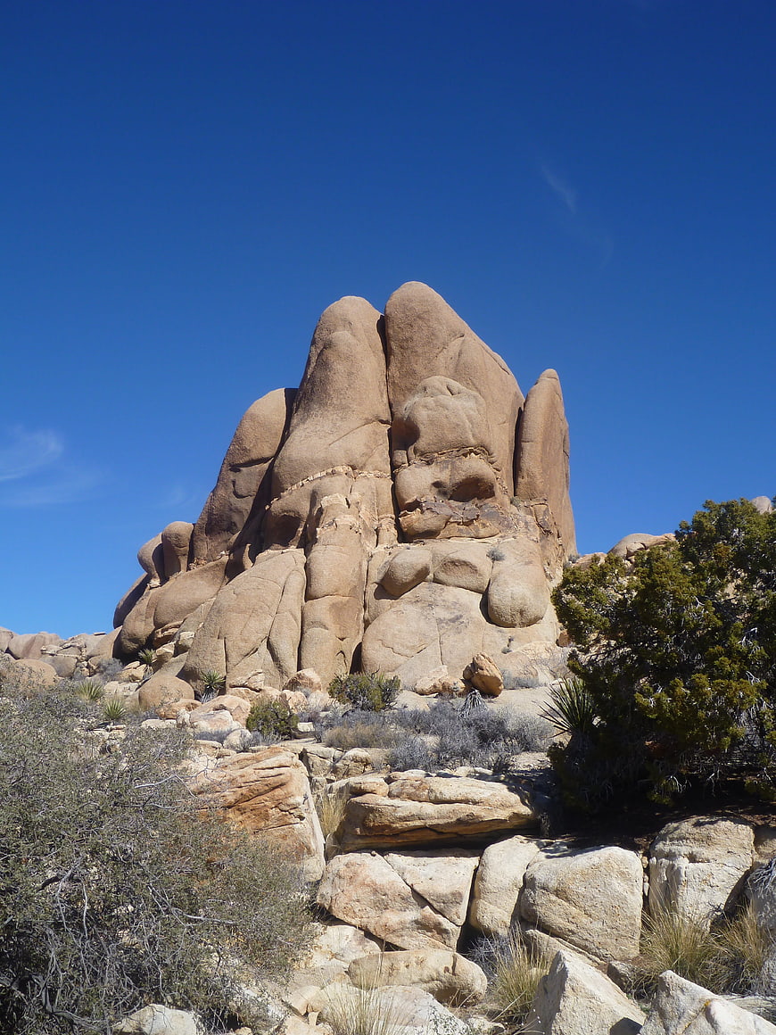 Massive desert rock formation against clear blue sky