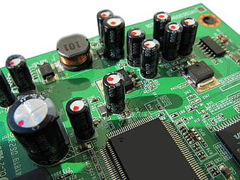 Close-up of green circuit board with capacitors and chips