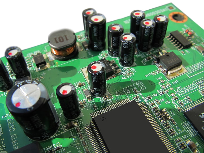 Close-up of green circuit board with capacitors and chips