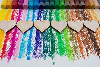 Wooden hearts on colorful chalk rainbow stripes background