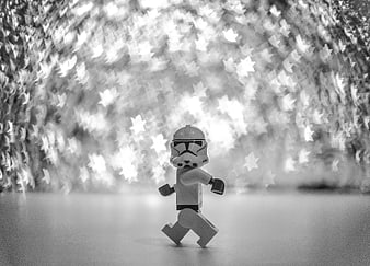 Black and white LEGO Star Wars stormtrooper walking against starry bokeh background