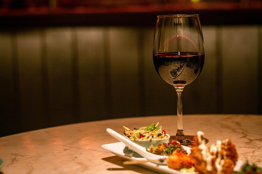 Glass of red wine with appetizers on marble table