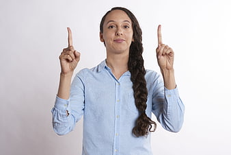 Woman Pointing Up with Both Index Fingers on White Background