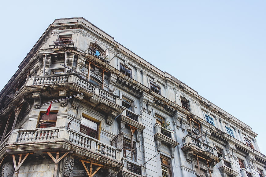 Low angle view of weathered historic building with balconies