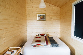 Cozy wooden bedroom interior with patterned quilt and window