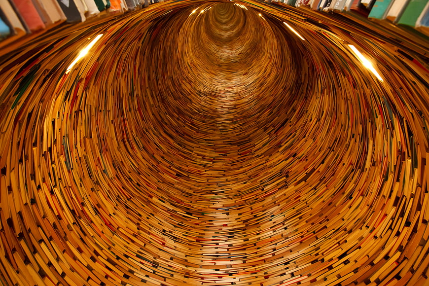 Surreal fisheye tunnel of books in a library