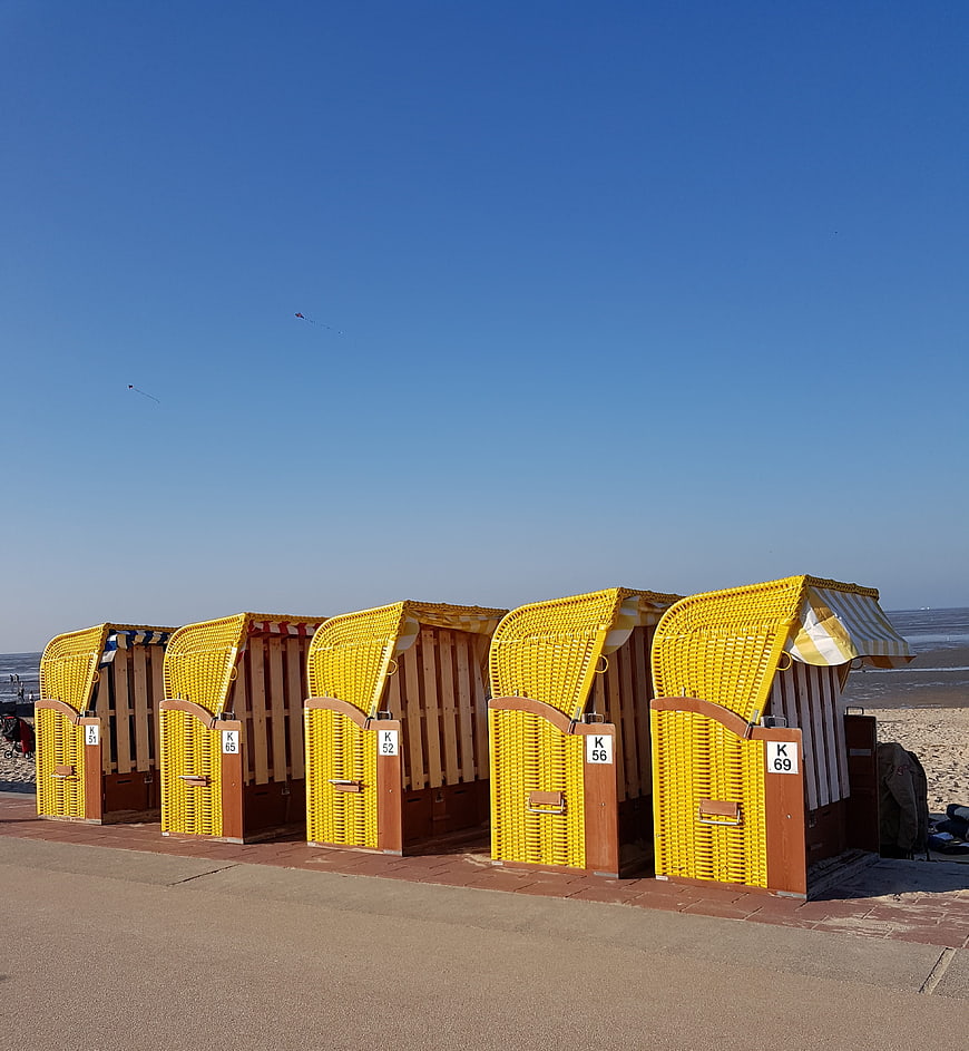 Row of yellow beach huts on sandy shore
