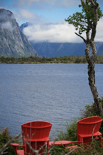 Red Adirondack Chairs Overlooking Mountain Lake