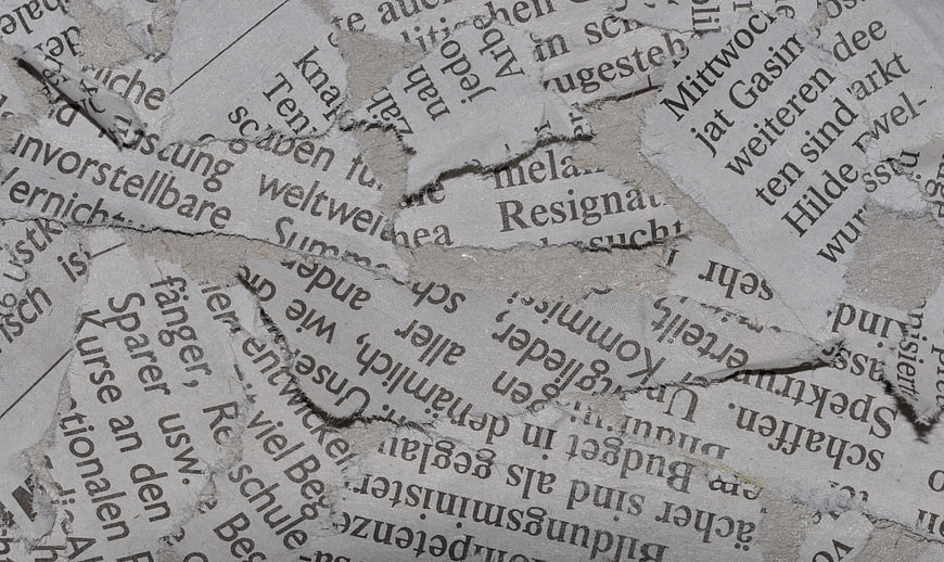 Torn German Newspaper Textures on Wall Background