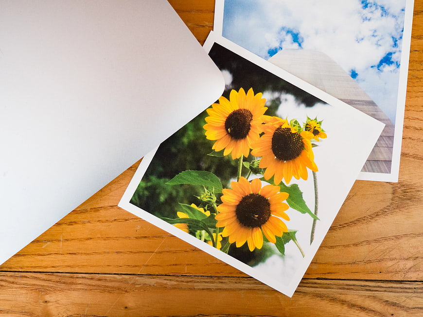 Printed Sunflower Photos on Wooden Desk with White Envelope
