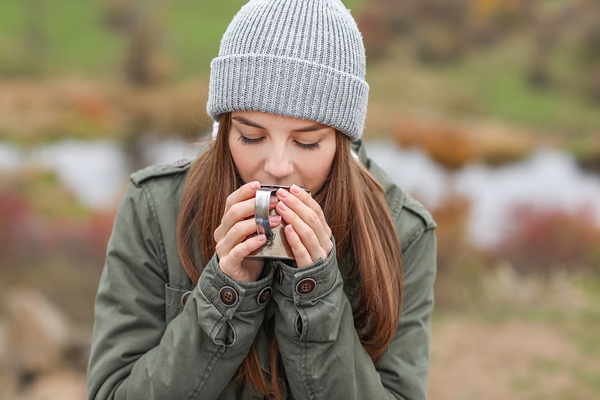 Woman in Beanie Drinking Hot Beverage Outdoors