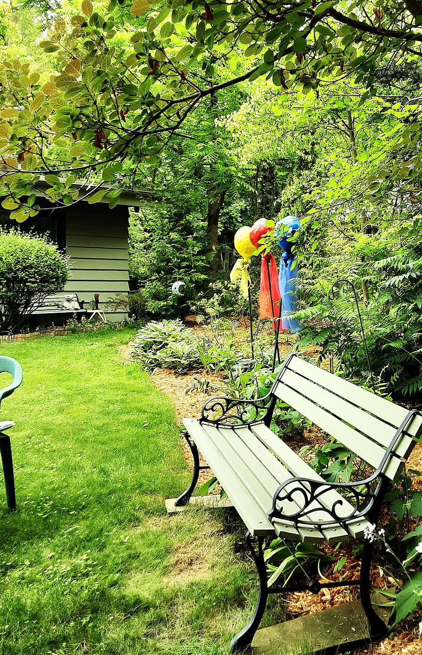 Peaceful Garden Bench with Colorful Windsocks