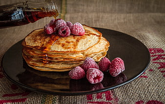 Stack of pancakes with raspberries and syrup