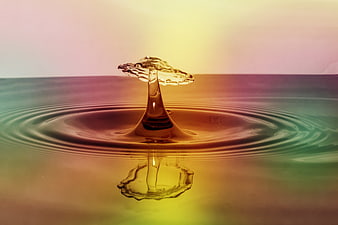 Colorful water droplet splash with ripples and reflection