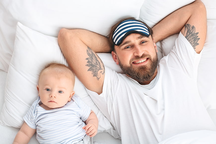 Happy Father and Baby Sleeping in Bed