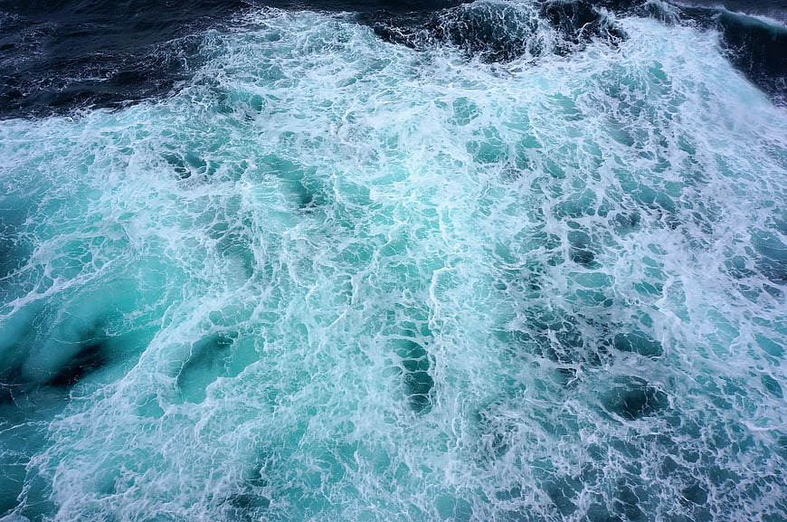 Aerial View of Turbulent Turquoise Ocean Waves and White Foam