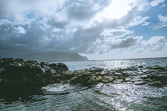 Dramatic Rocky Coastline with Cloudy Sky and Ocean Waves