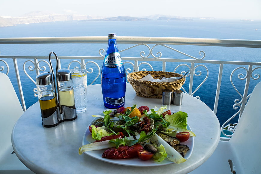 Mediterranean salad and water on a balcony overlooking the Aegean Sea